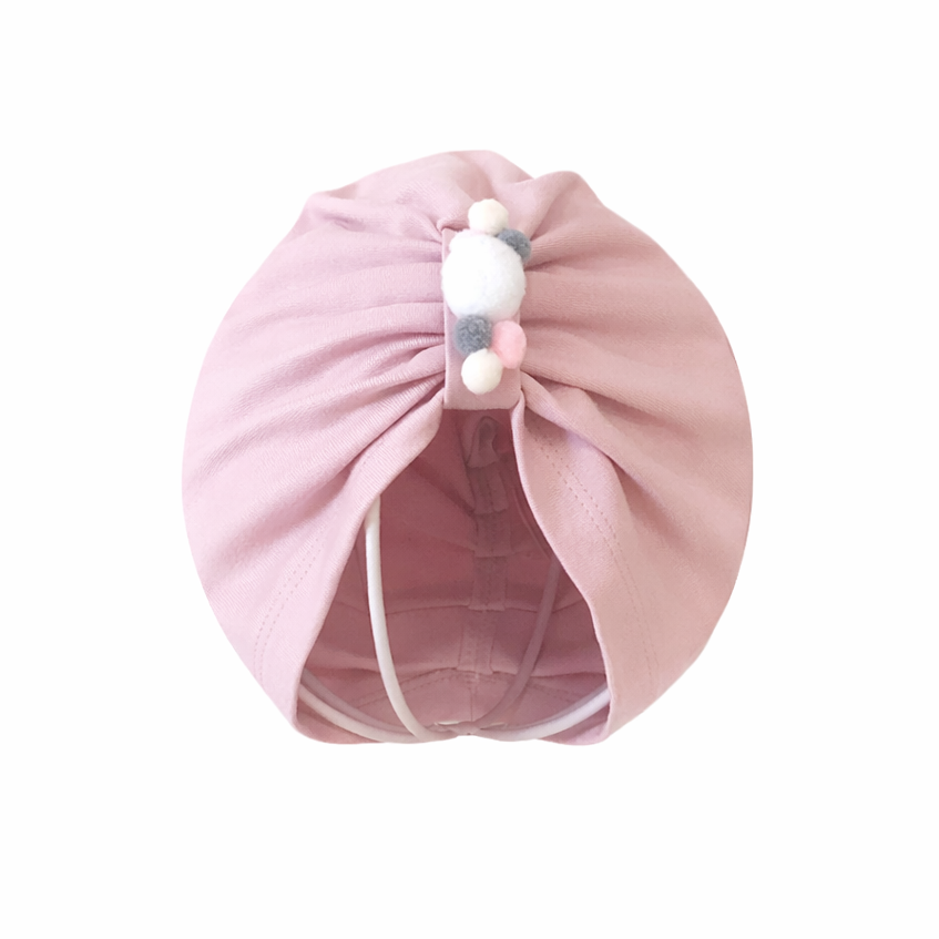 Pink hair turban with decorative beads on a white background
