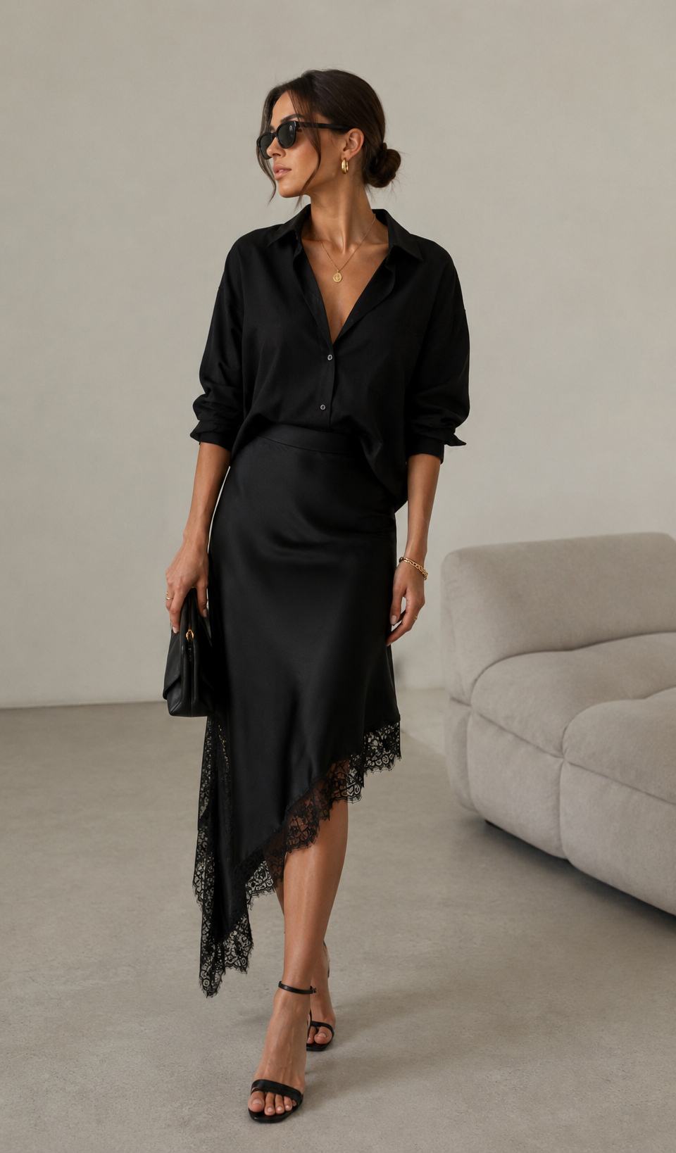 Woman wearing a black outfit with a skirt and shirt in a minimalistic room.