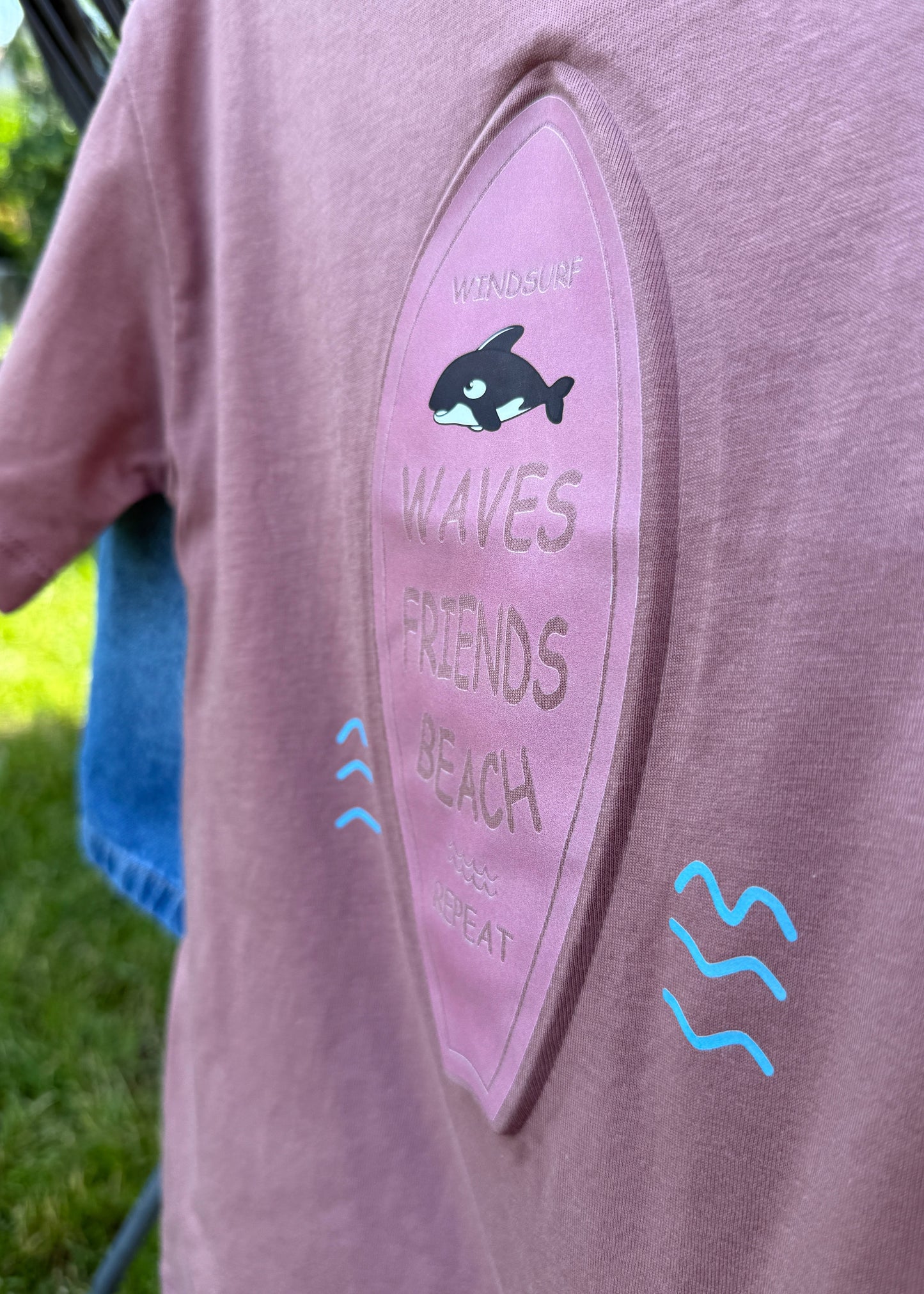 Close-up of a pink hoodie with text and graphics on a blurred background