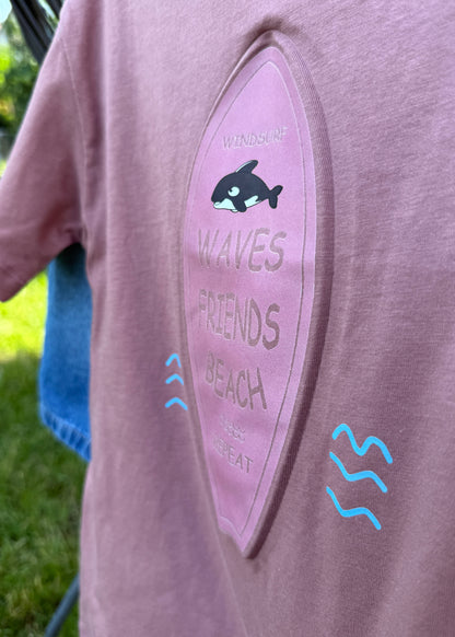 Close-up of a pink hoodie with text and graphics on a blurred background