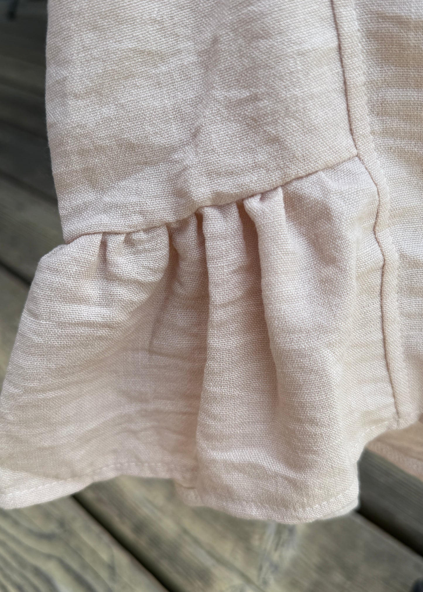 Close-up of beige fabric with a wooden surface in the background