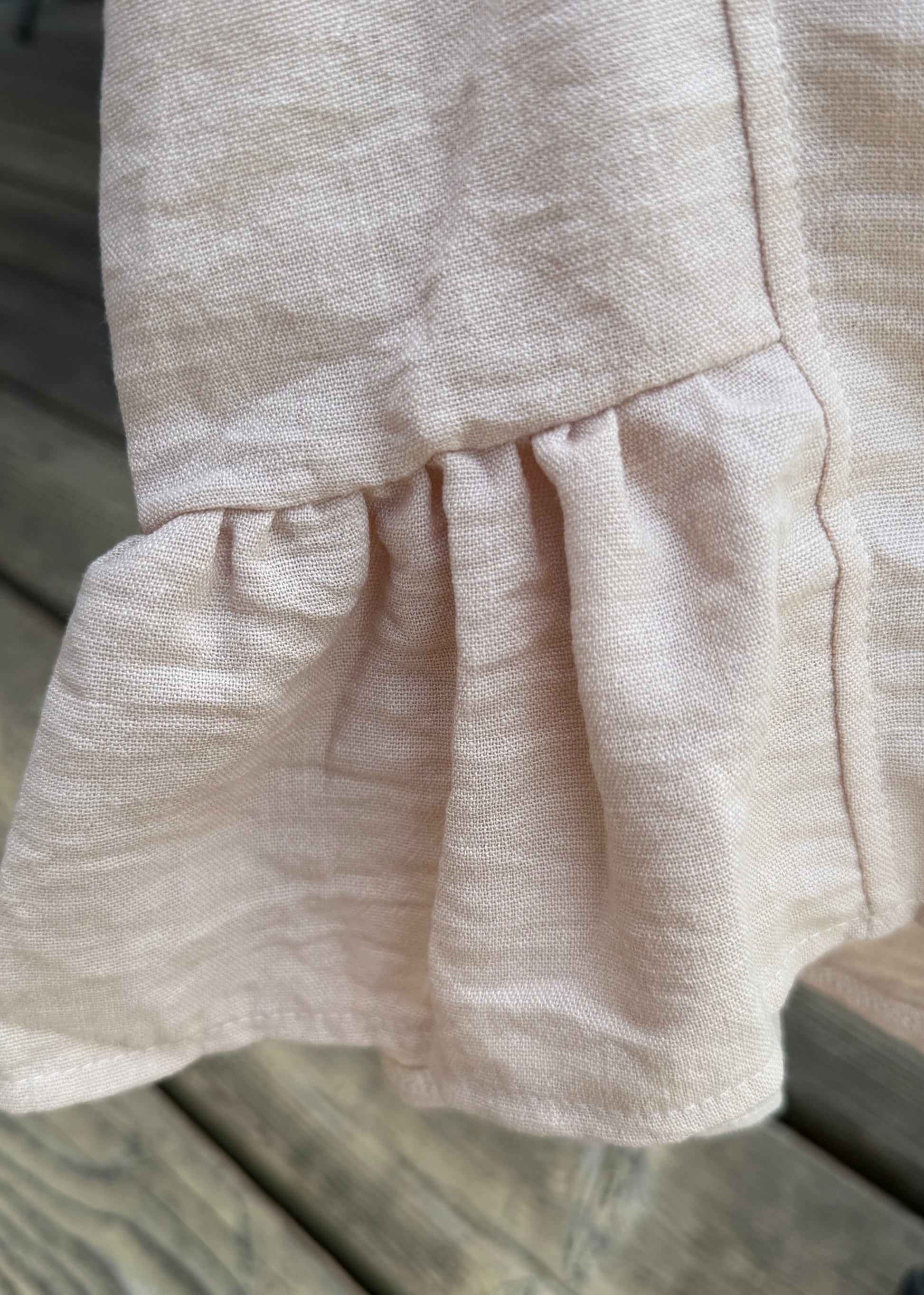 Close-up of beige fabric with a wooden surface in the background
