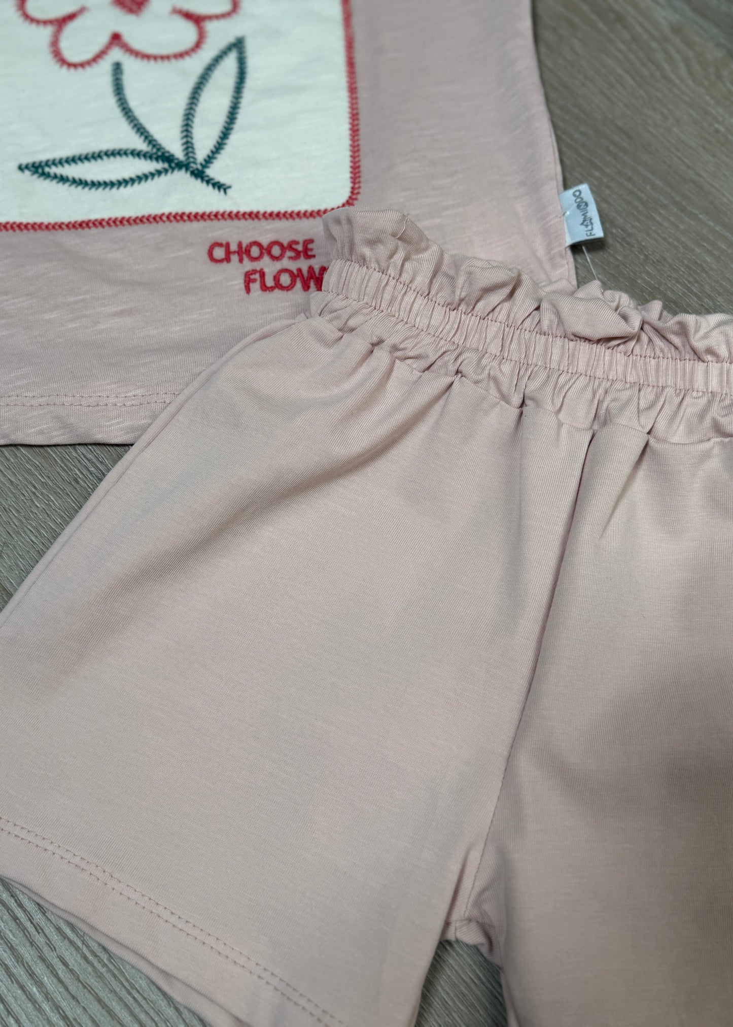 Beige pants with 'Choose Flow' text on a textured surface