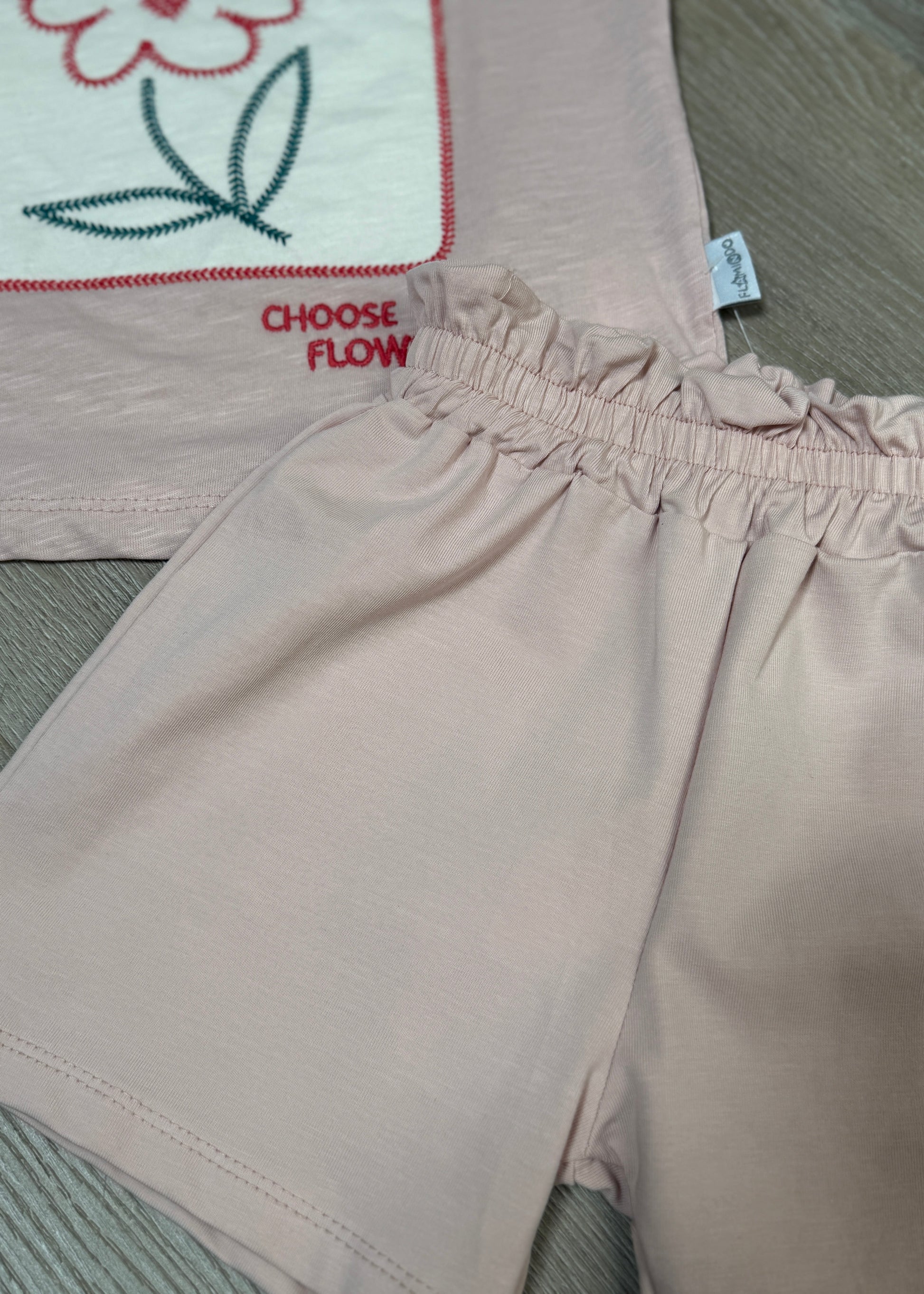 Beige pants with 'Choose Flow' text on a textured surface