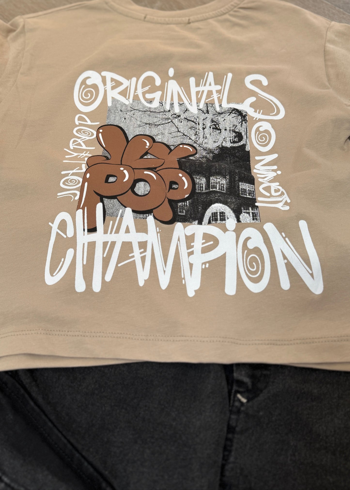 Beige t-shirt with graphic design and text on a plain background