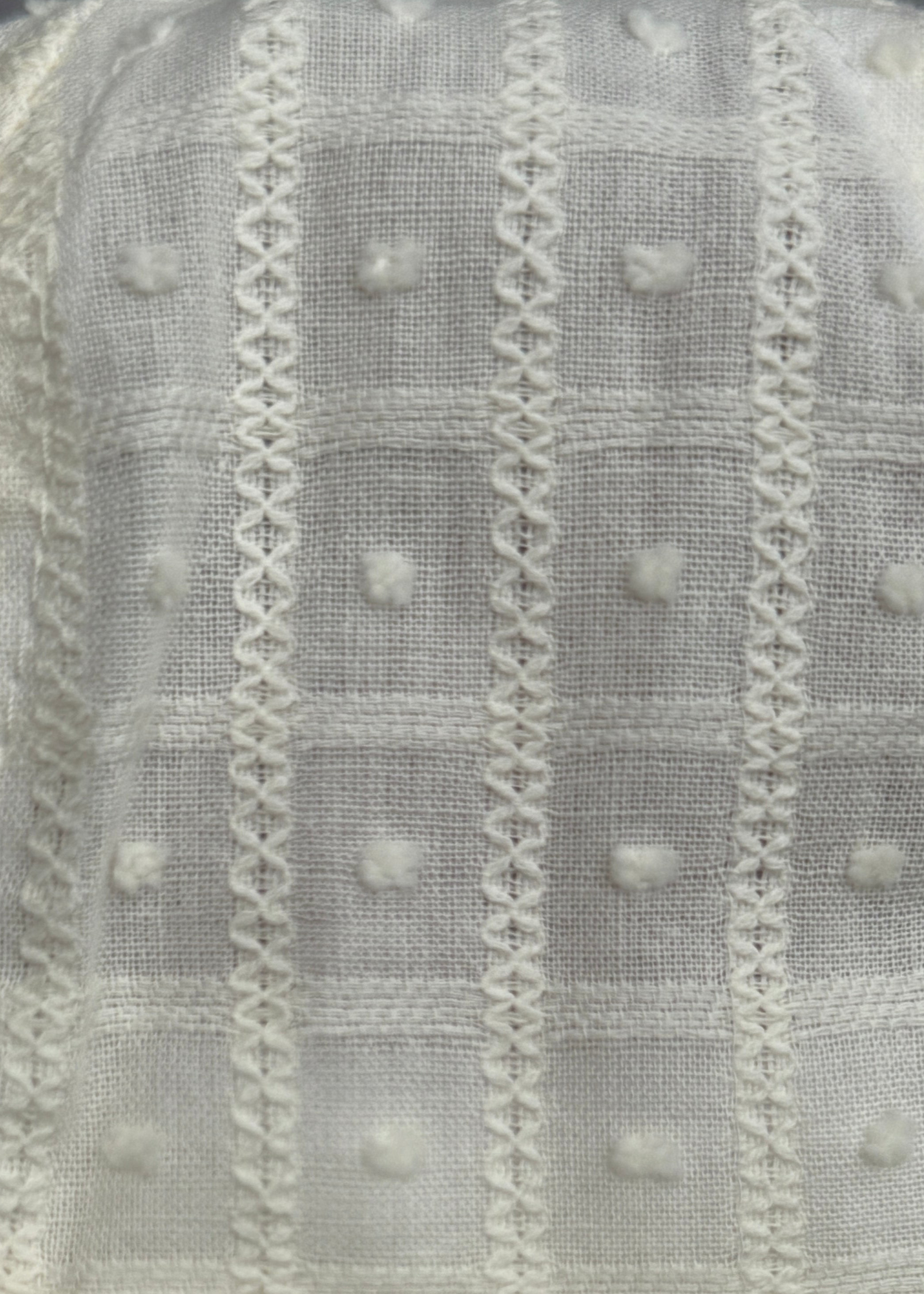Close-up of textured fabric with patterns and small round elements