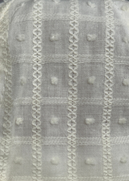Close-up of textured fabric with patterns and small round elements