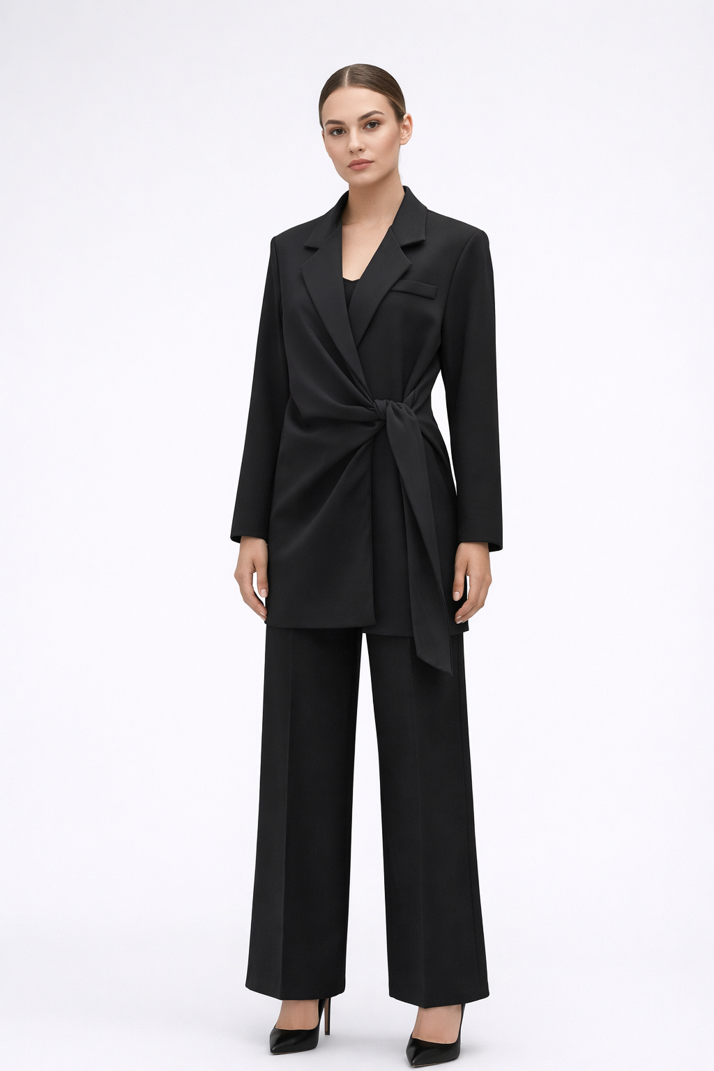 Juodas kostiumas su surišamu svarku baltam fone ant merginos