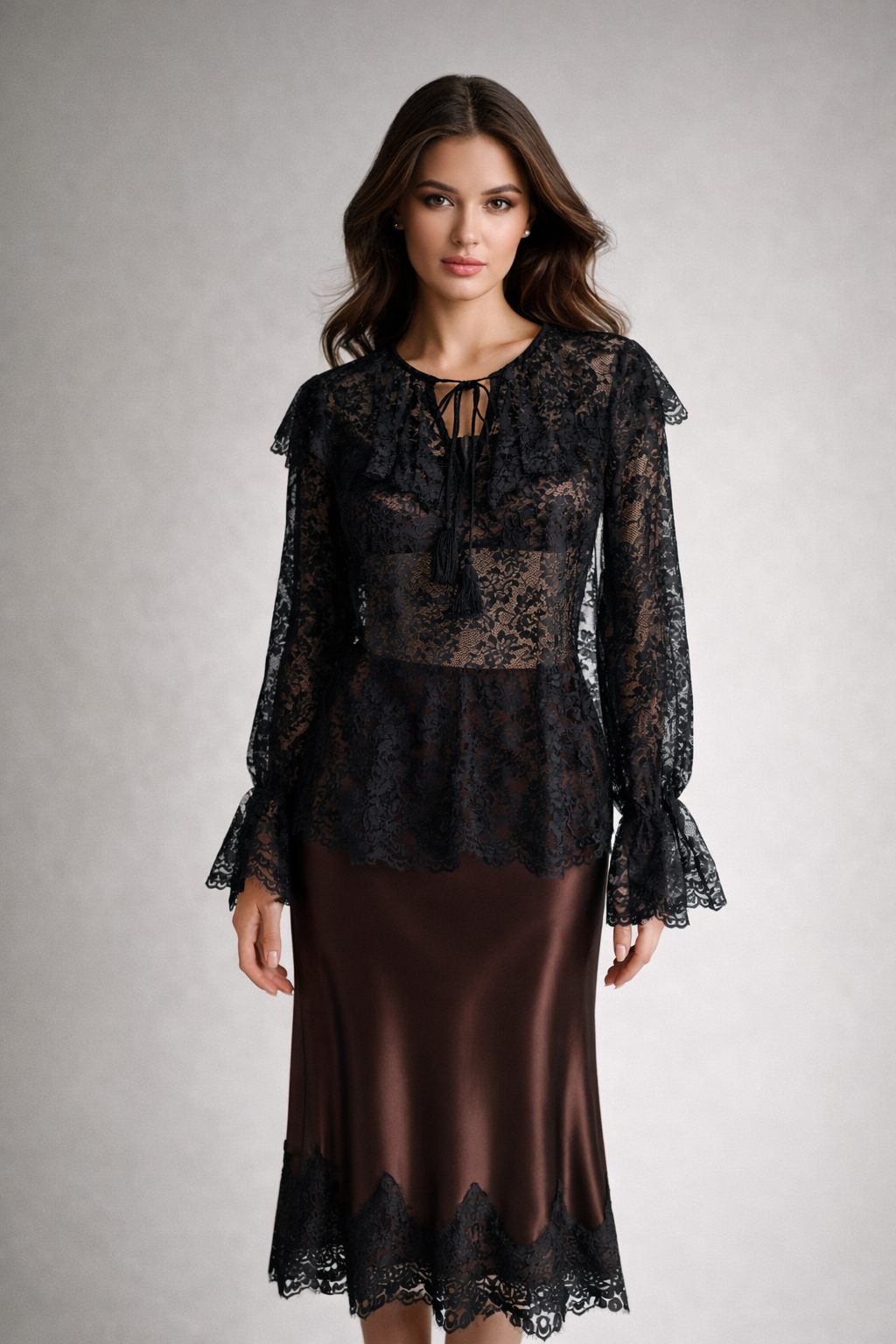 Woman wearing a black lace top and brown skirt on a gray background