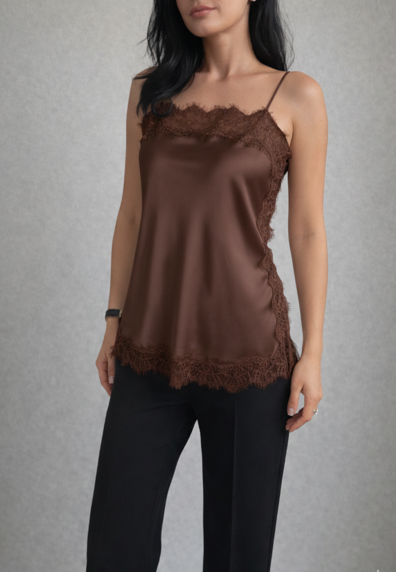 Woman wearing a brown lace-trimmed top and black pants against a gray background