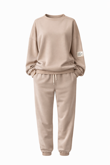 Beige tracksuit with a small patch on the sleeve against a white background