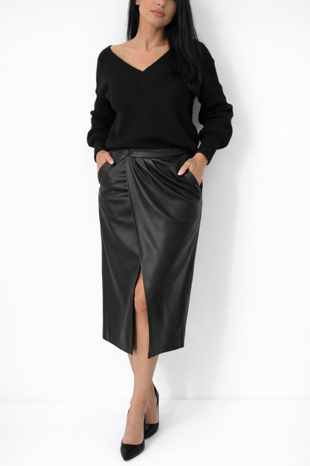 Woman wearing a black top and black satin skirt against a white background