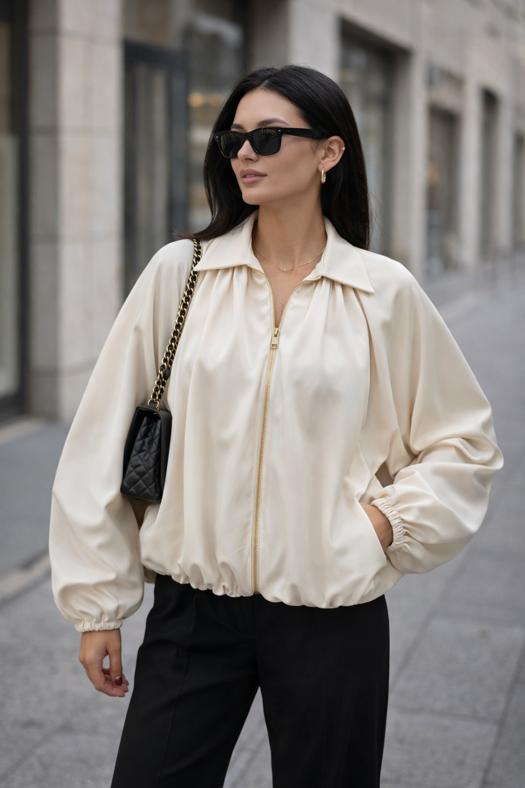 Woman wearing a cream jacket and black pants on a city street.