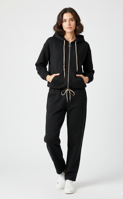 Person wearing a black hoodie and pants on a white background