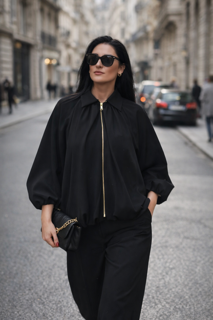 Woman in a black outfit walking on a city street