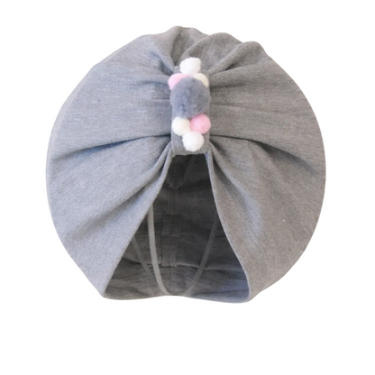 Gray baby turban with colorful pom-poms on a white background